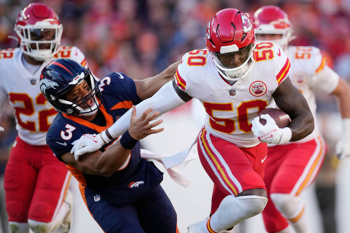 Kansas City Chiefs linebacker Willie Gay, right, runs past Denver Broncos quarterback Russell W ...