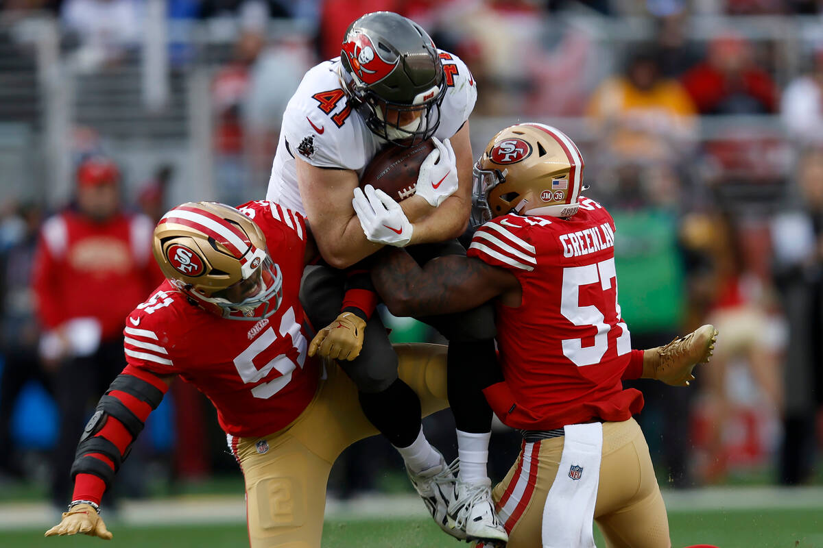 Tampa Bay Buccaneers tight end Ko Kieft, middle, is tackled by San Francisco 49ers linebacker A ...