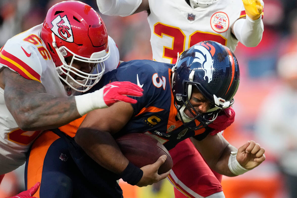 Denver Broncos quarterback Russell Wilson, right, is sacked by Kansas City Chiefs defensive tac ...