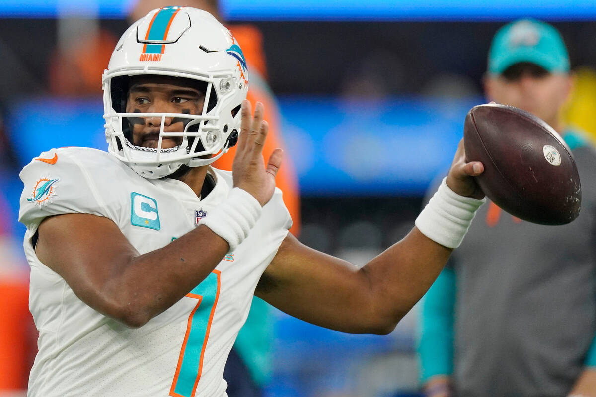 Miami Dolphins quarterback Tua Tagovailoa (1) warms up before an NFL football game against the ...