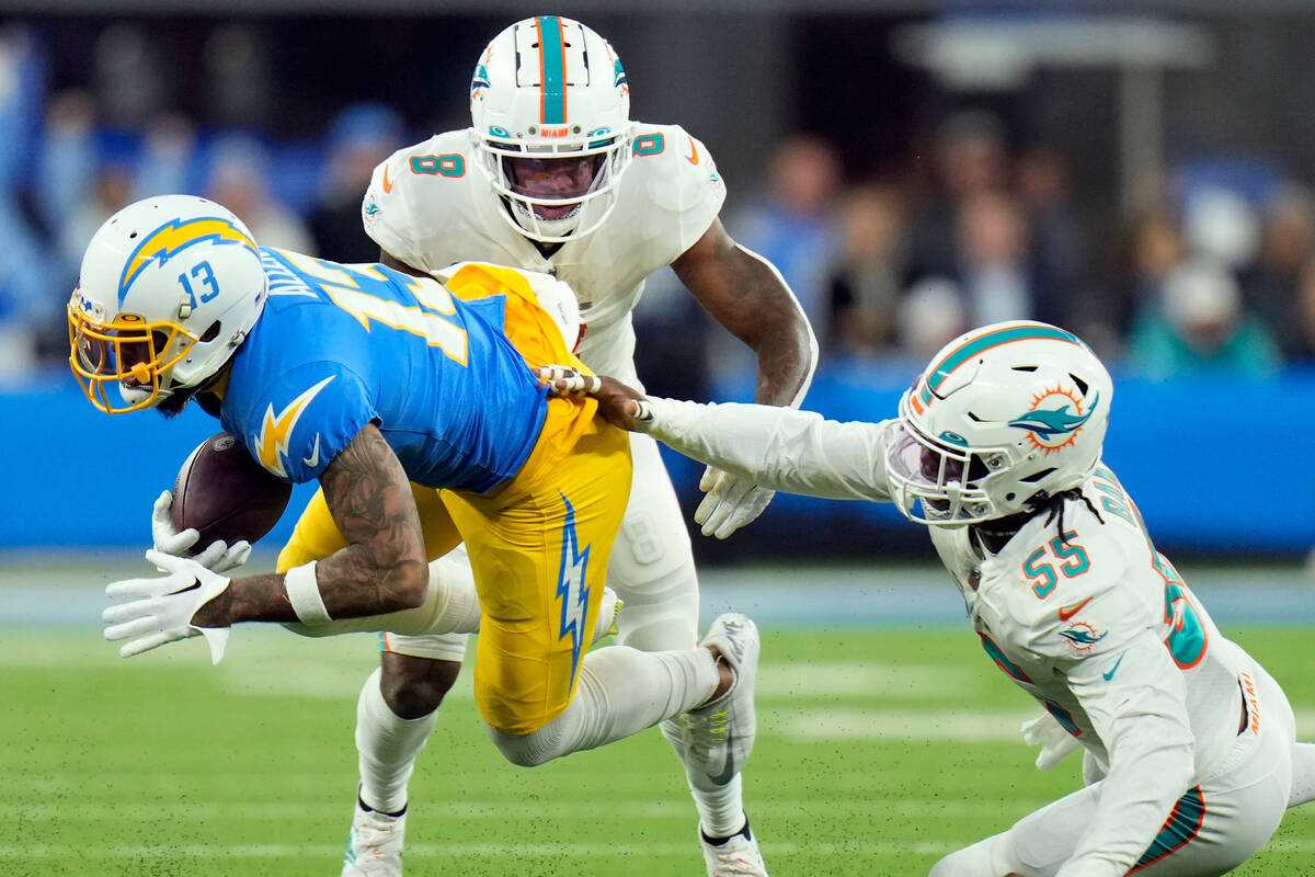 Los Angeles Chargers wide receiver Keenan Allen (13) is tackled by Miami Dolphins linebacker Je ...