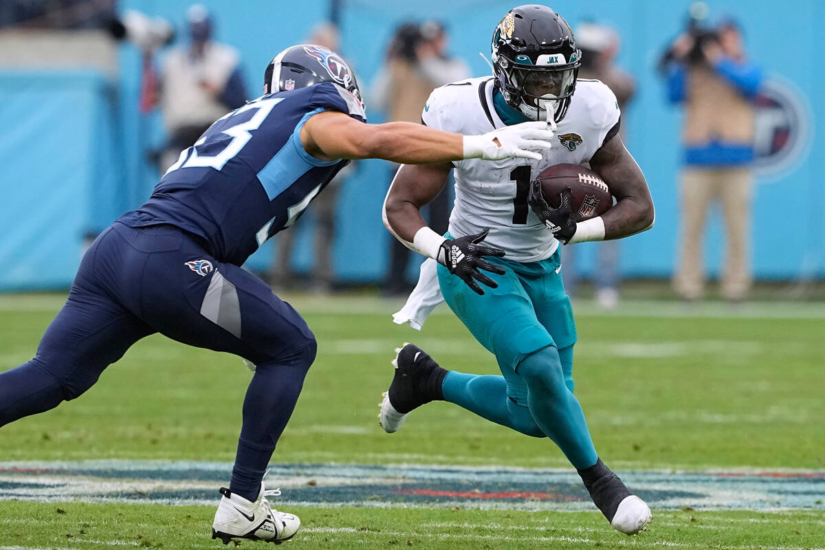 Jacksonville Jaguars running back Travis Etienne Jr. (1) runs with the ball as Tennessee Titans ...