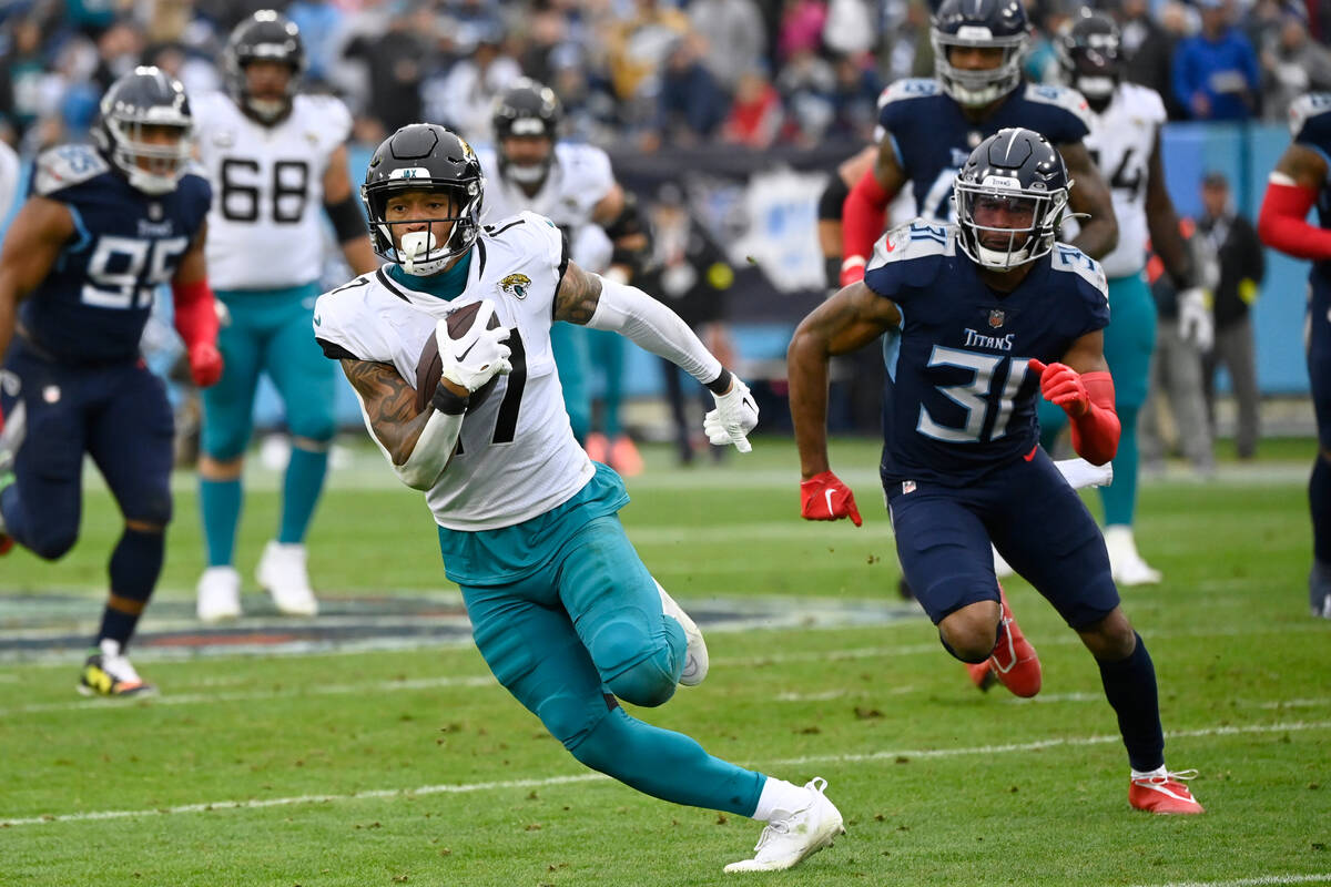 Jacksonville Jaguars tight end Evan Engram (17) runs with the ball as Tennessee Titans safety K ...