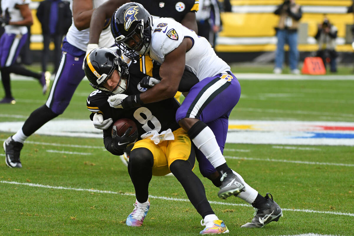 Pittsburgh Steelers quarterback Kenny Pickett (8) is tackled by Baltimore Ravens linebacker Roq ...