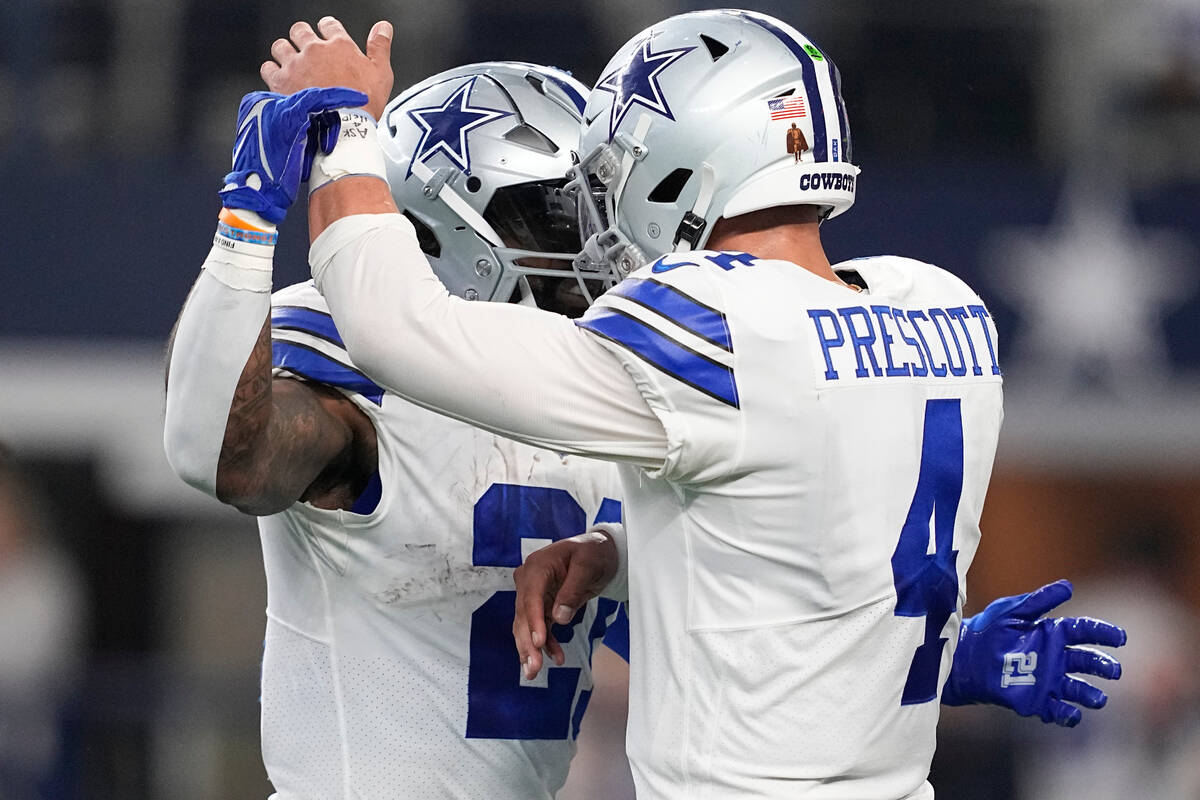 Dallas Cowboys running back Ezekiel Elliott (21) celebrates with quarterback Dak Prescott (4) a ...