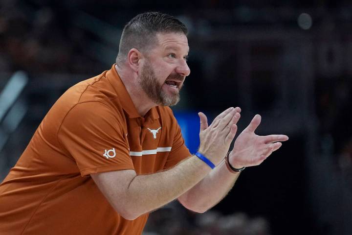 Texas head coach Chris Beard talks to his players during the first half of an NCAA college bask ...