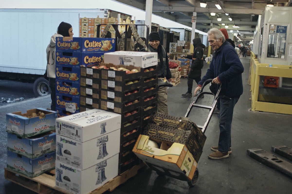 FILE - People shop for fruits and vegetables at S. Katzman Produce at the Hunts Point Produce M ...