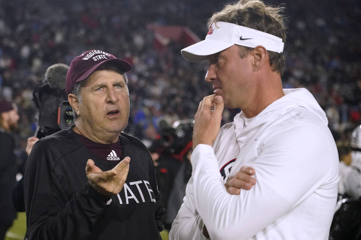 Mississippi State coach Mike Leach, left, talks with Mississippi coach Lane Kiffin before an NC ...