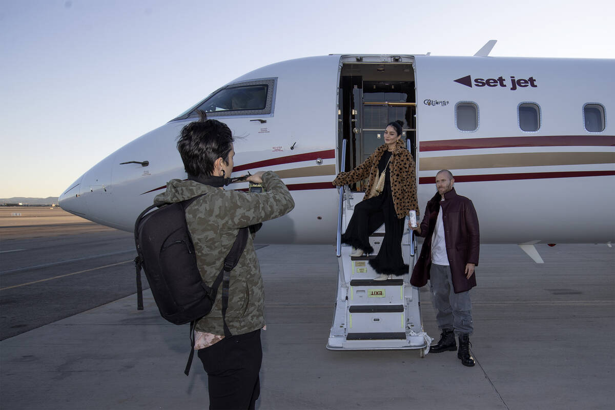 Actors Vanessa Hudgens, center, and Oliver Trevena, right, pose for photographs in front of a S ...