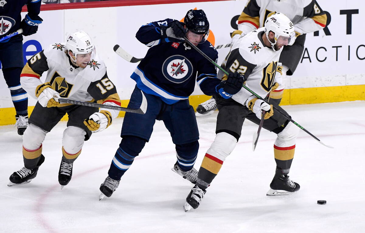 Vegas Golden Knights' Jake Leschyshyn (15) and Michael Amadio (22) battle with Winnipeg Jets' N ...