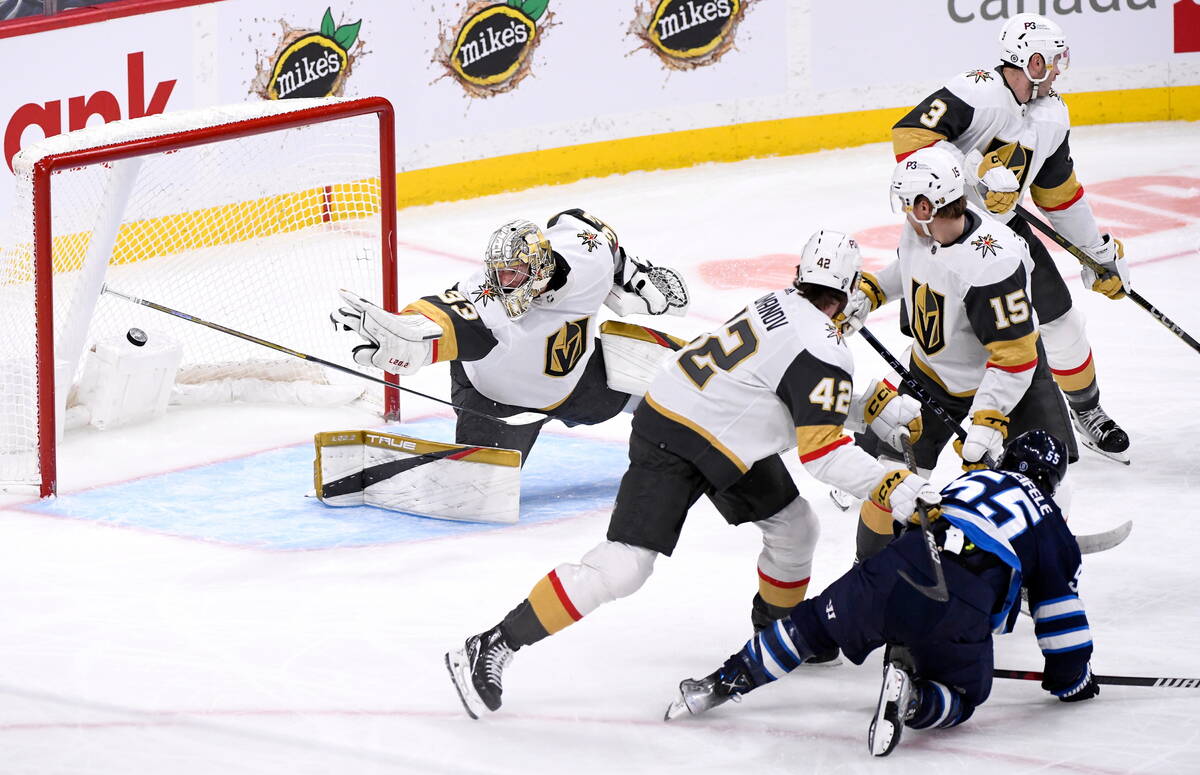 Winnipeg Jets' Mark Scheifele (55) scores on Vegas Golden Knights' goaltender Adin Hill (33) du ...