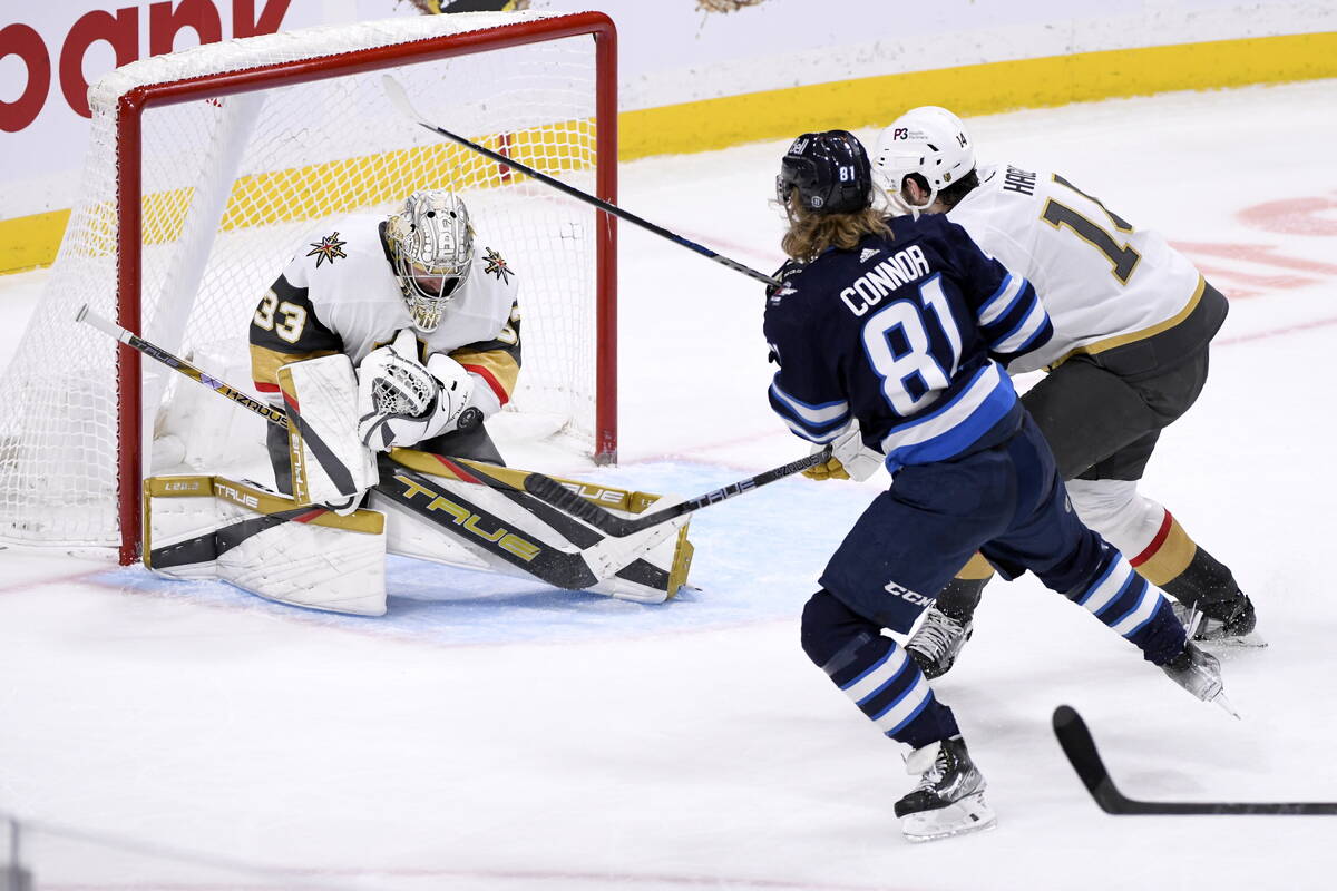 Vegas Golden Knights goaltender Adin Hill (33) makes a save on Winnipeg Jets' Kyle Connor (81) ...