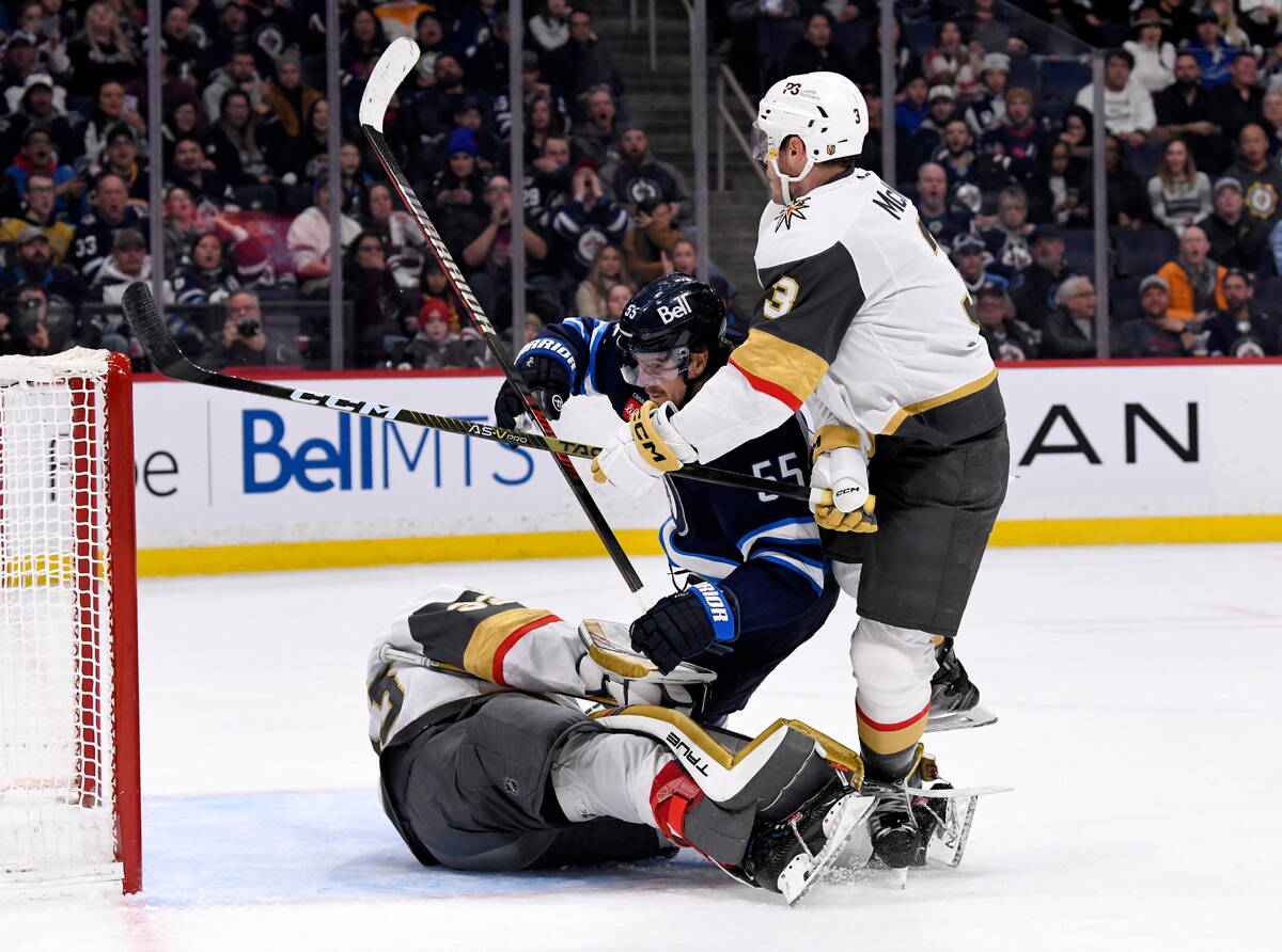 Vegas Golden Knights' Brayden McNabb (3) ties up Winnipeg Jets' Mark Scheifele (55) in front of ...