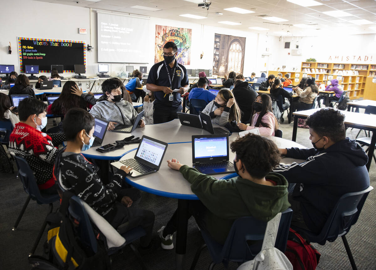 Cristian Calata, center, a substitute teacher at Bailey Middle School, works with three classes ...