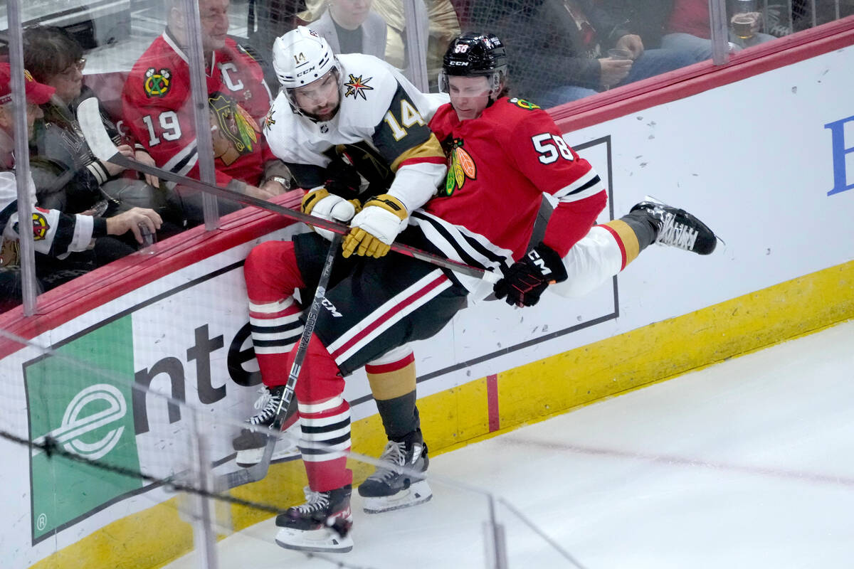 Chicago Blackhawks' MacKenzie Entwistle (58) checks Vegas Golden Knights' Nicolas Hague into th ...