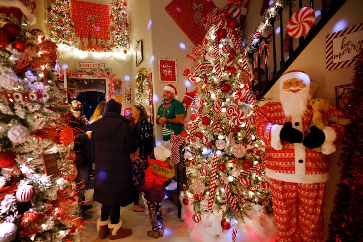 Co-owner Victor Cardenas, right, greets visitors at the entrance of the Candy Cane House, as th ...