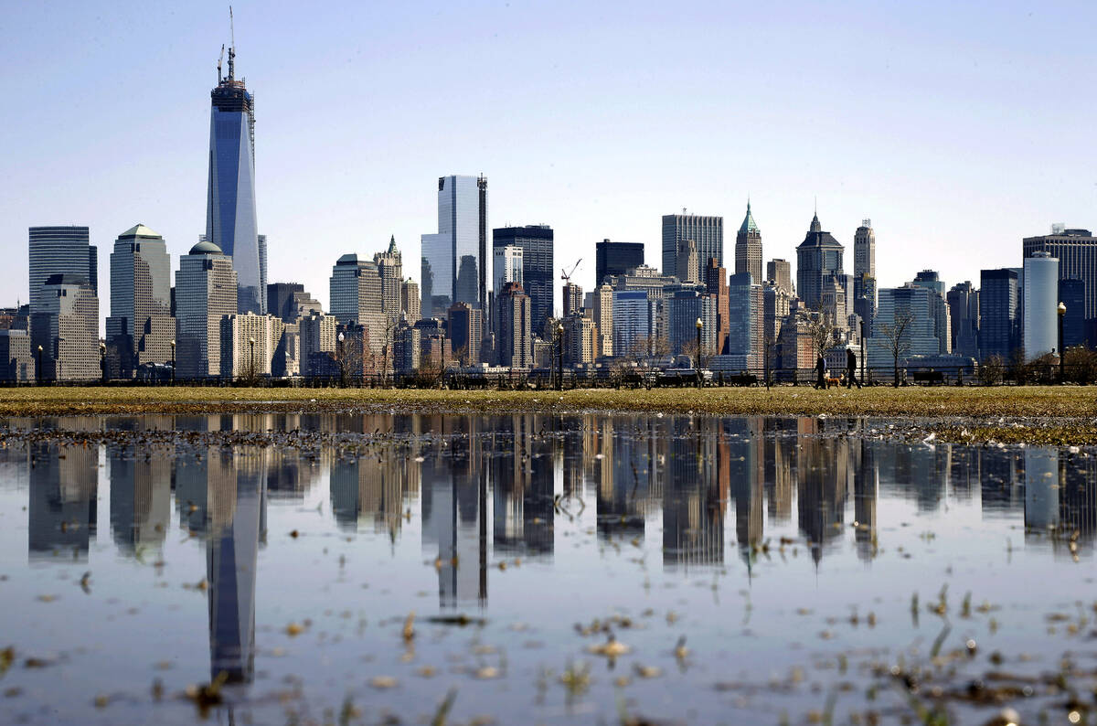 FILE - New York's Lower Manhattan skyline, including the One World Trade Center, left, is refle ...