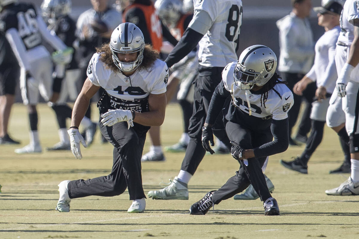 Raiders wide receiver Mack Hollins (10), left, and Davante Adams (17) stretch during practice a ...