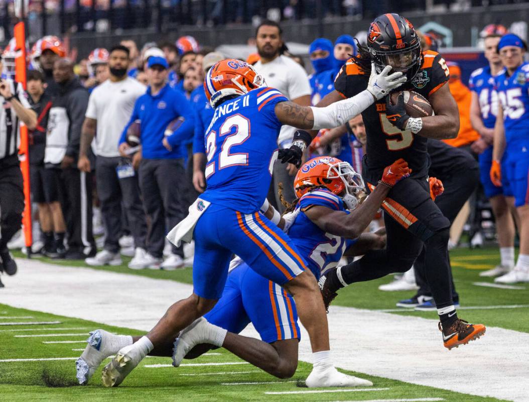 Oregon State Beavers running back Deshaun Fenwick (5) is driven out of bounds after a long run ...