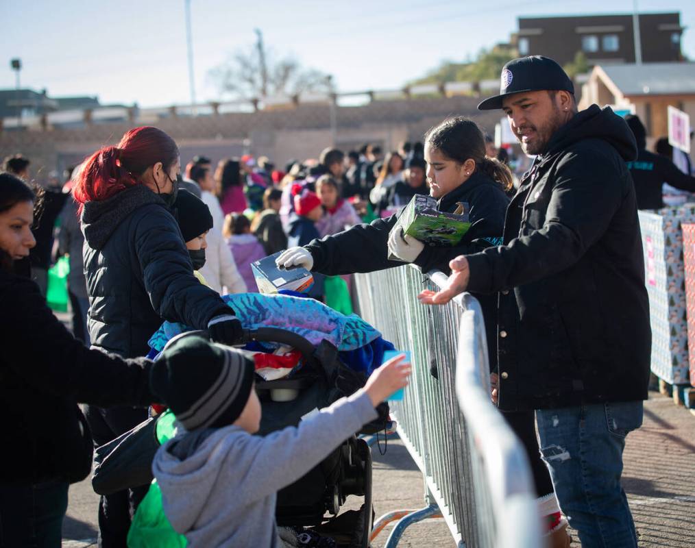 Anistyn Reis, left, 11, and Keanan Tantog, right, of Mongos Hood, pass out toys to families dur ...