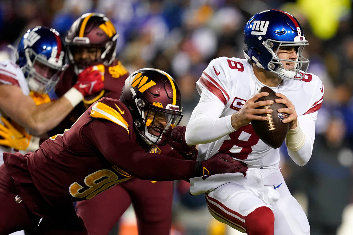 Washington Commanders defensive end Montez Sweat (90) tries to bring down New York Giants quart ...