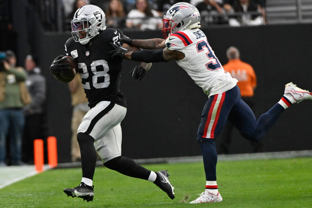 New England Patriots cornerback Jonathan Jones pushes Las Vegas Raiders running back Josh Jacob ...