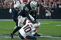 Las Vegas Raiders defensive end Chandler Jones (55) stiff arms New England Patriots quarterback ...