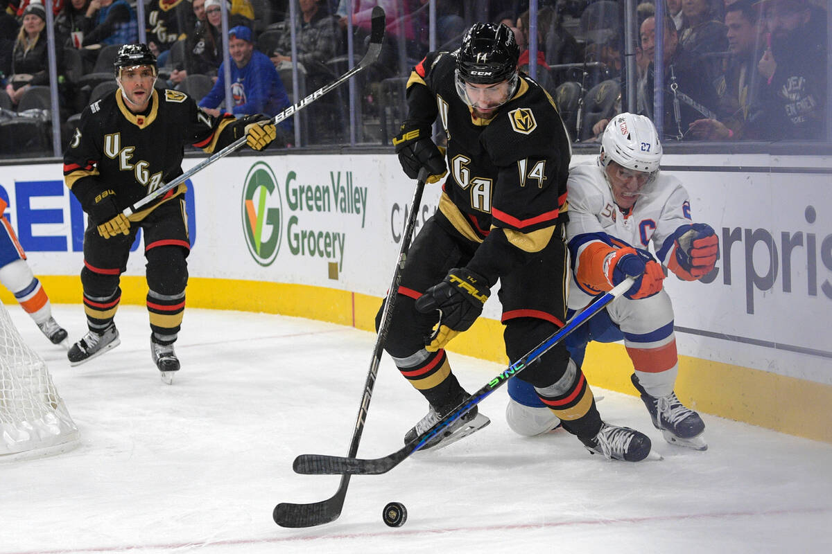 Vegas Golden Knights defenseman Nicolas Hague (14) gets the puck from New York Islanders left w ...