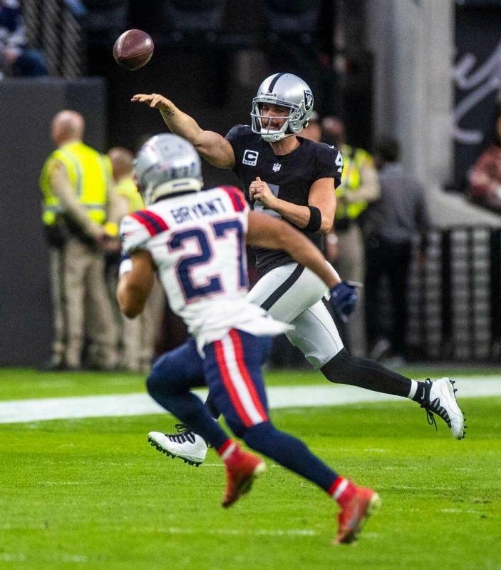 Raiders quarterback Derek Carr (4) gets off a pass over New England Patriots cornerback Myles B ...