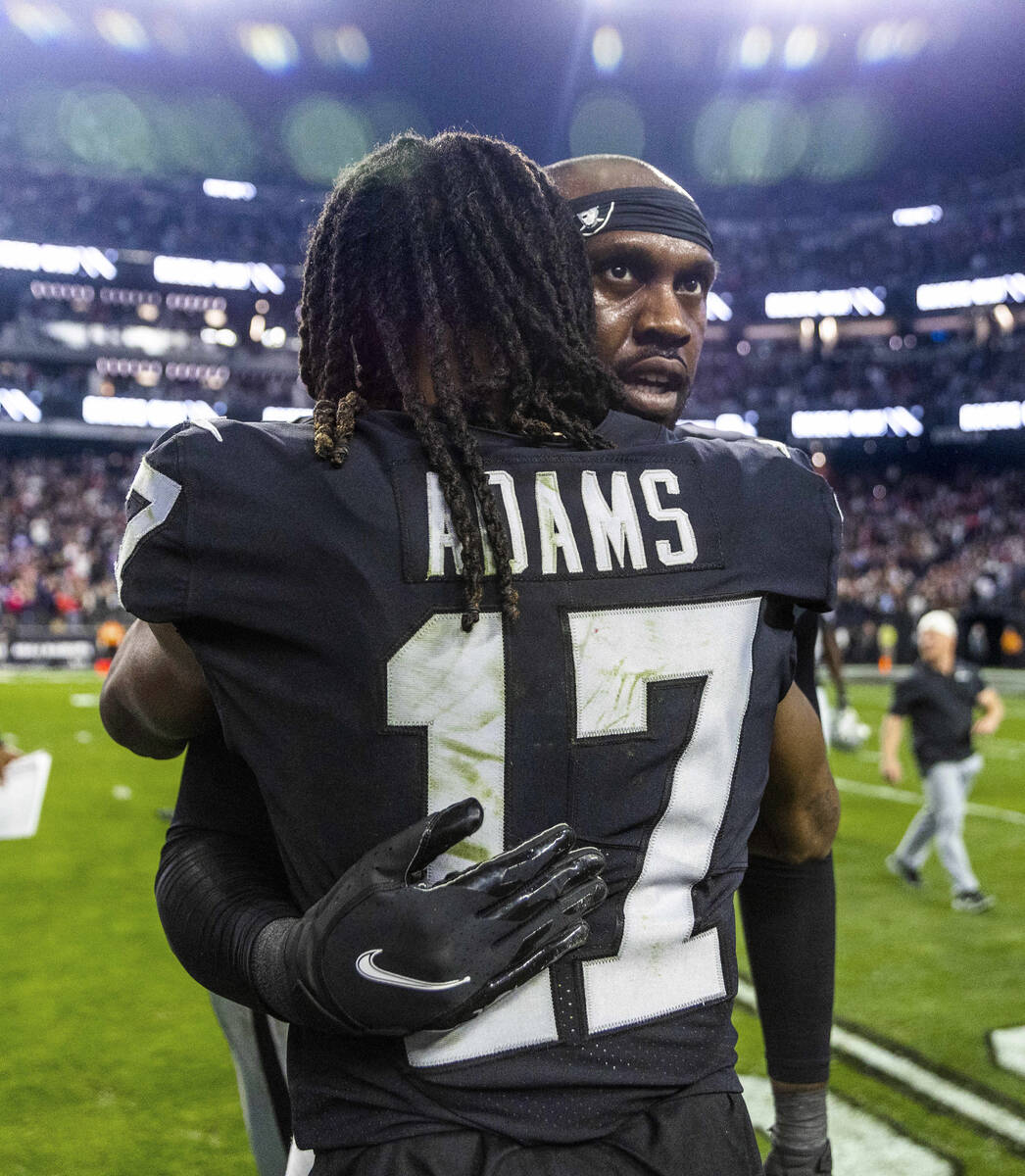 Raiders defensive end Chandler Jones (55) is hugged by teammate wide receiver Davante Adams (17 ...