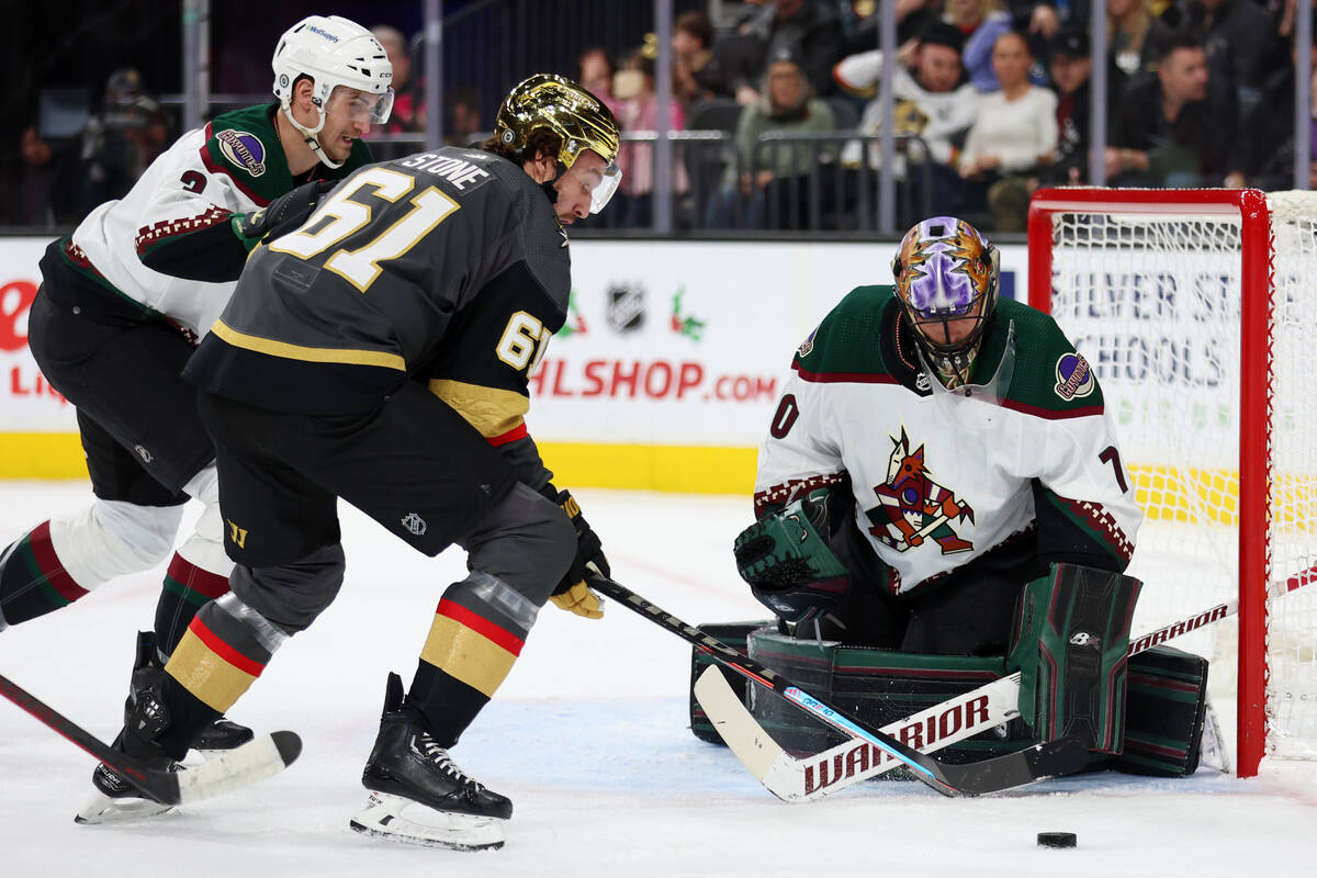 Vegas Golden Knights right wing Mark Stone (61) fights for the puck under pressure from Arizona ...