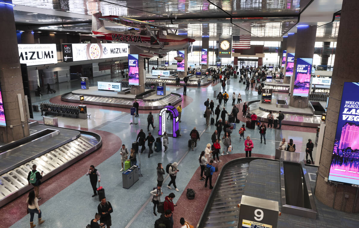 Arriving passengers make their way through baggage claim at Harry Reid International Airport on ...