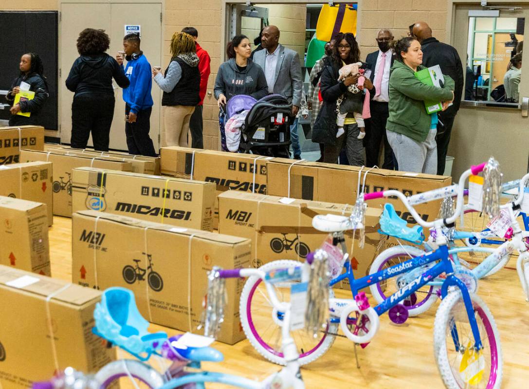 Children and their parents arrive to receive toys and bikes at Pearson Community Center, on Wed ...