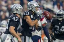 Raiders wide receiver Mack Hollins (10) flips the football and celebrates with long snapper Tre ...