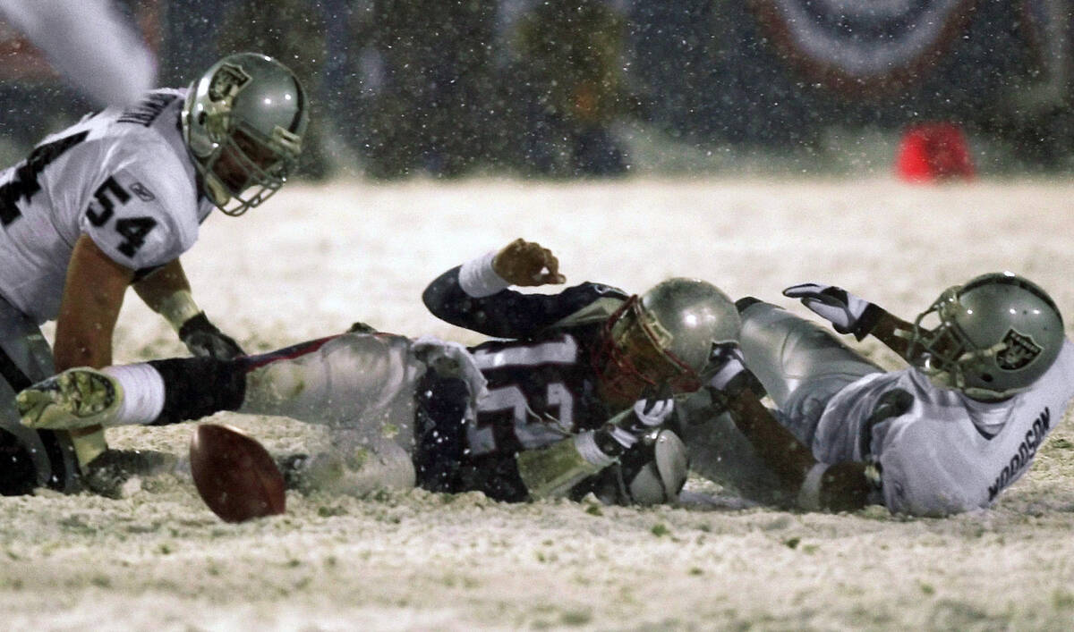 FILE - In this Jan. 19, 2002, file photo, New England Patriots quarterback Tom Brady (12) loses ...