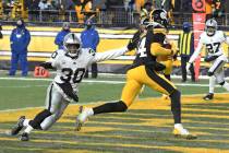 Pittsburgh Steelers wide receiver George Pickens (14) scores with Las Vegas Raiders safety Duro ...