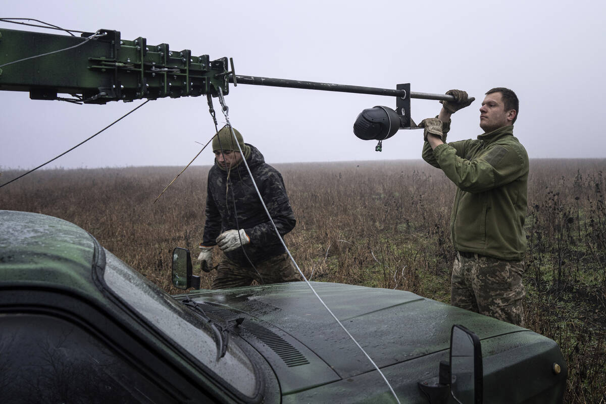 Ukrainian servicemen from 127 brigade mount a remote camera on the telescopic tower installed o ...