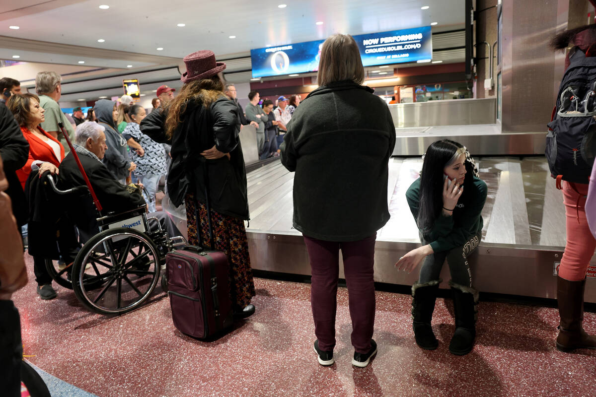 Travelers, including Raylene O’Connor of Tonto Basin, Ariz., seated, wait to retrieve their l ...