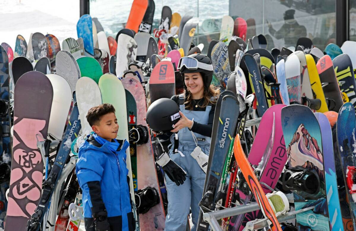 Amber Huggins helps her son Mason Arias, 8, to take off a helmet after snowboarding, Monday, De ...