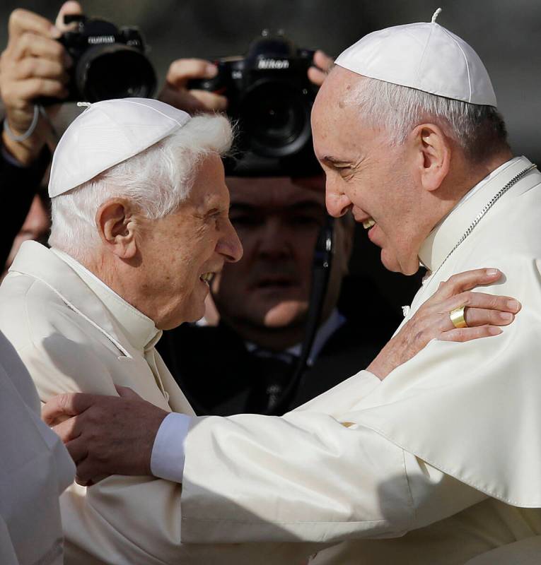 FILE - Pope Francis, right, hugs Pope Emeritus Benedict XVI prior to the start of a meeting wit ...