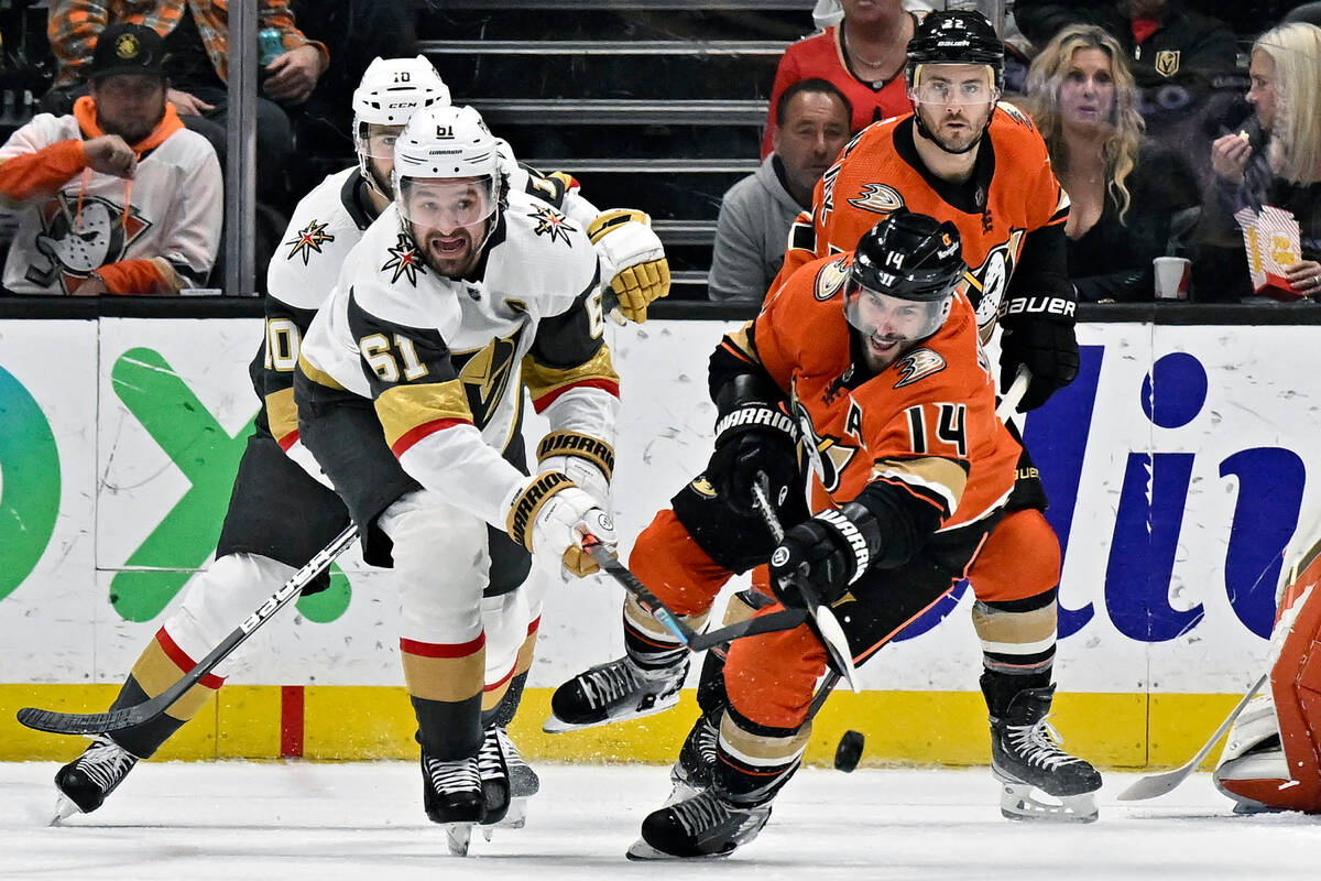 Anaheim Ducks center Adam Henrique, right, clears the puck away from Vegas Golden Knights right ...