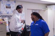 Desert Pines High School's wide receiver senior Darnell Washington, left, and assistant coach a ...