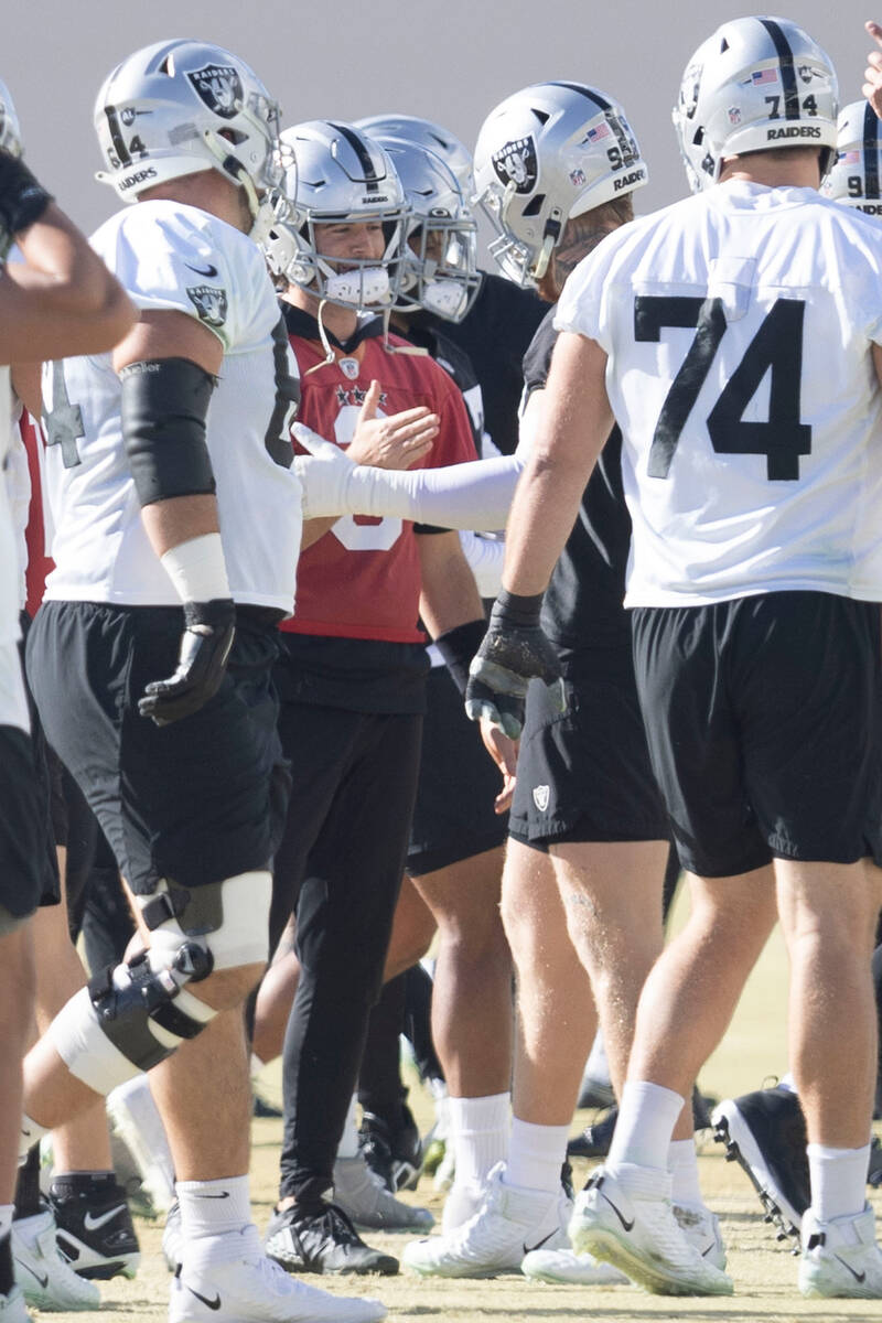 Raiders quarterback Jarrett Stidham (3), left center, shakes hands with defensive end Maxx Cros ...