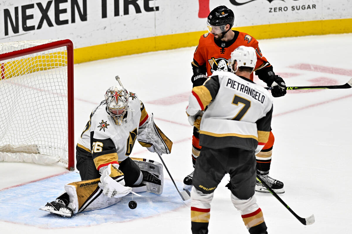 Vegas Golden Knights goaltender Logan Thompson, left, stops a shot in front of Anaheim Ducks ce ...