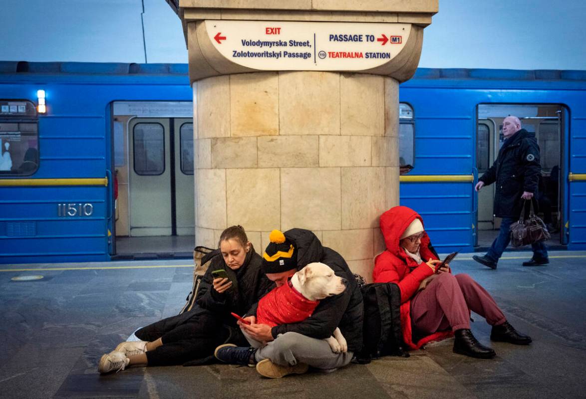 People sit in the subway station being used as a bomb shelter during a rocket attack in Kyiv, U ...