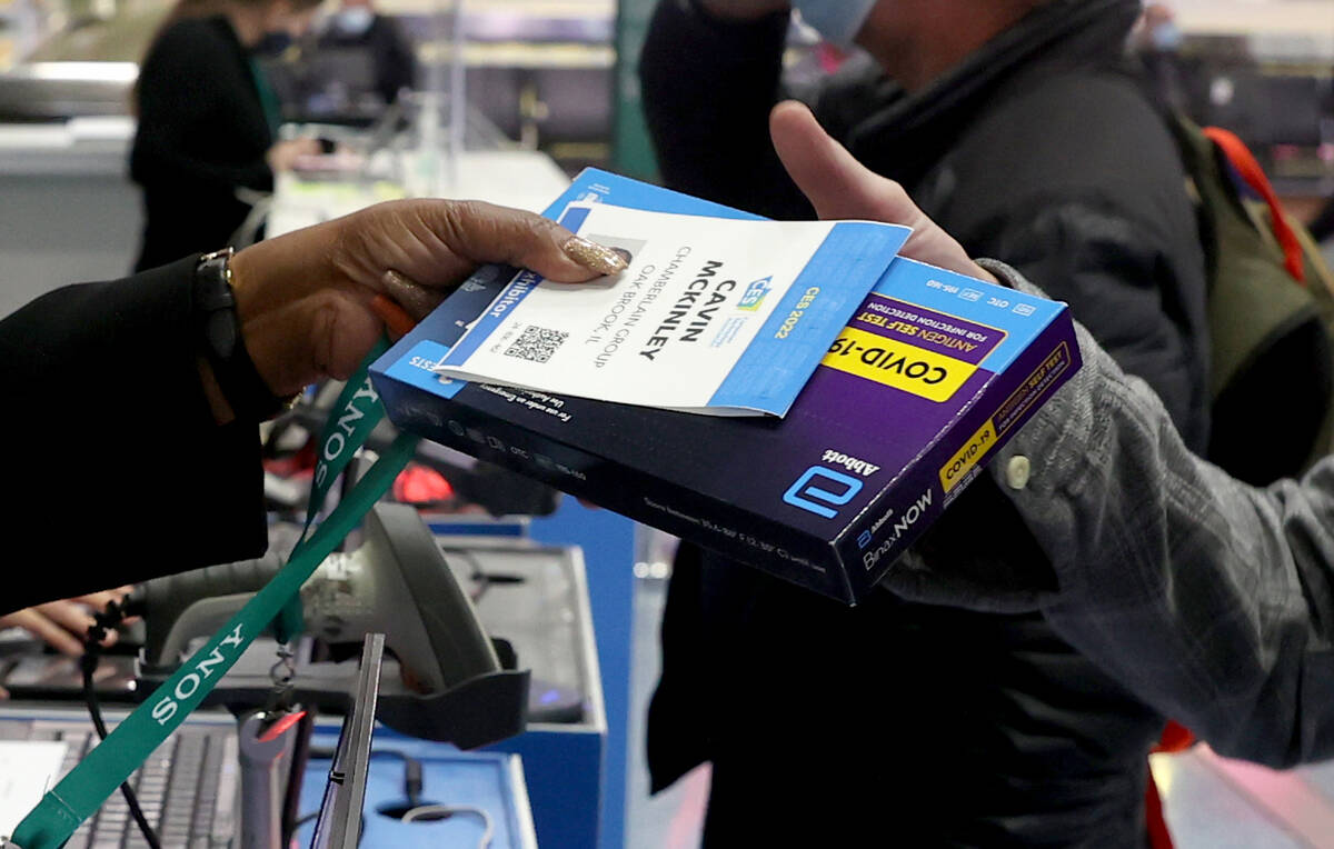 Cavin McKinley of Oak Brook, Ill. picks up his CES badge and COVID-19 test kit after landing at ...