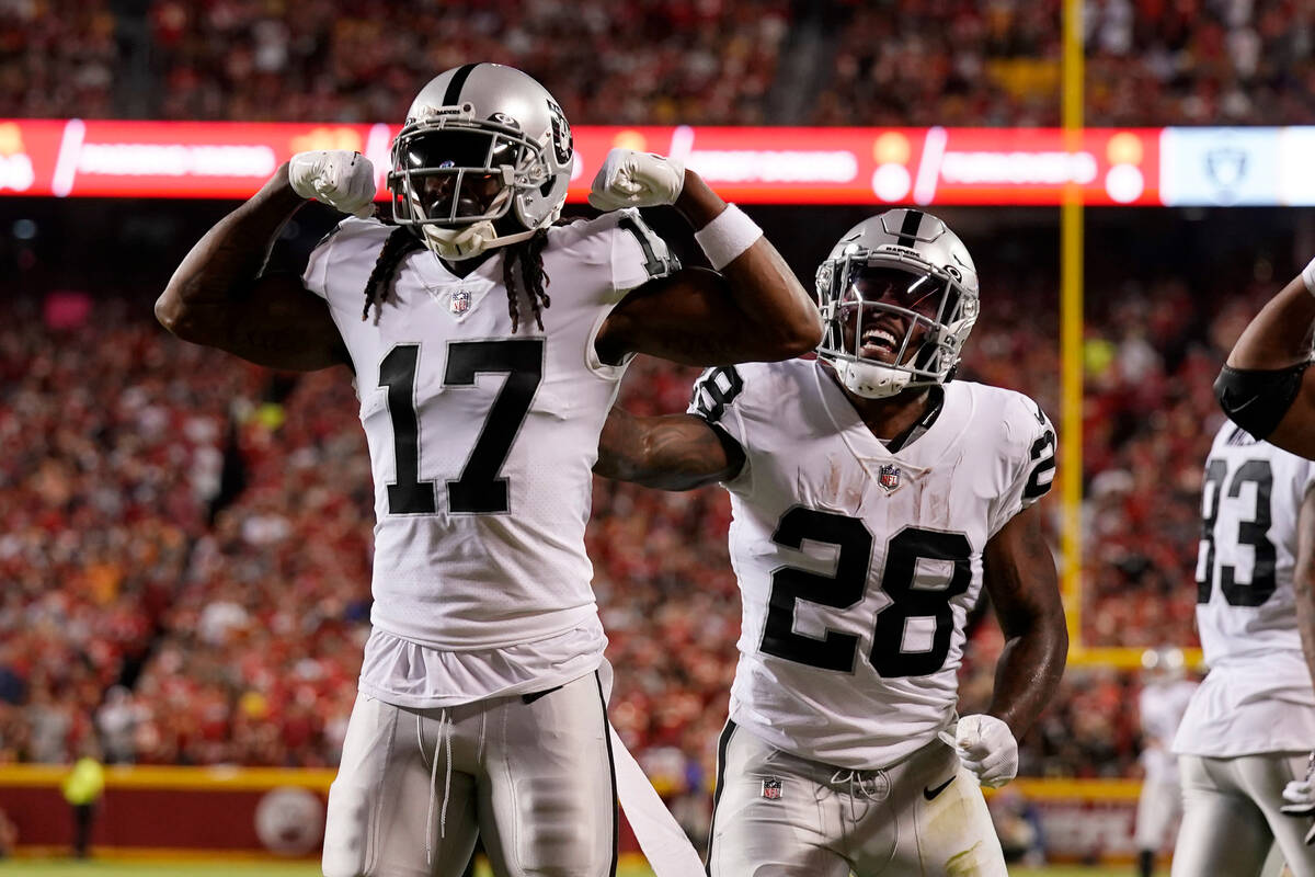 Las Vegas Raiders wide receiver Davante Adams (17) is congratulated by Josh Jacobs (28) after s ...