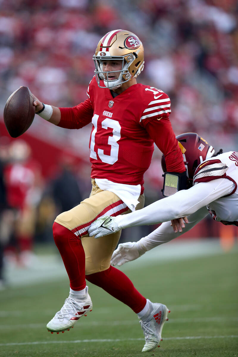 San Francisco 49ers quarterback Brock Purdy (13) is chased out of bounds by Washington Commande ...