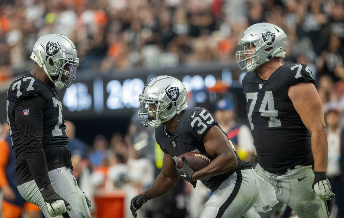 Raiders running back Zamir White (35) celebrates a big run with offensive tackles Thayer Munfor ...