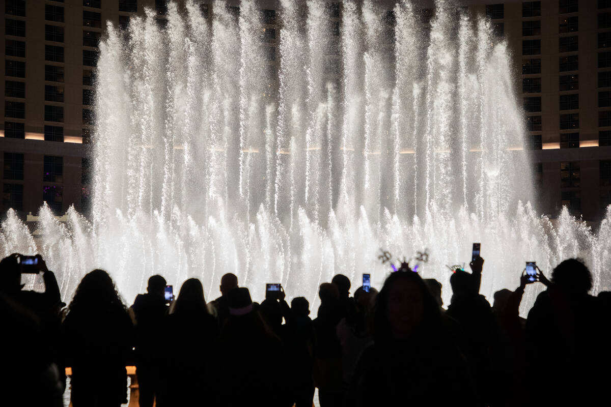 New Year’s Eve revelers watch the Bellagio fountain show on the Strip on Saturday, Dec. 31, 2 ...